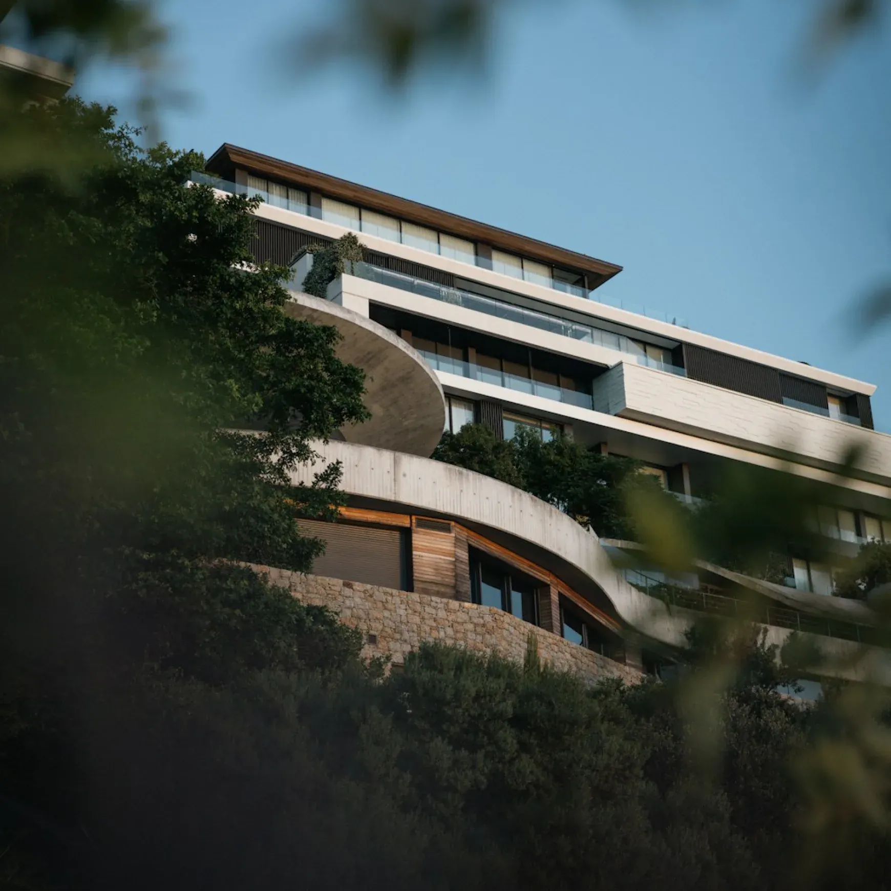 Edificio residenziale contemporaneo tra gli alberi visto dal basso